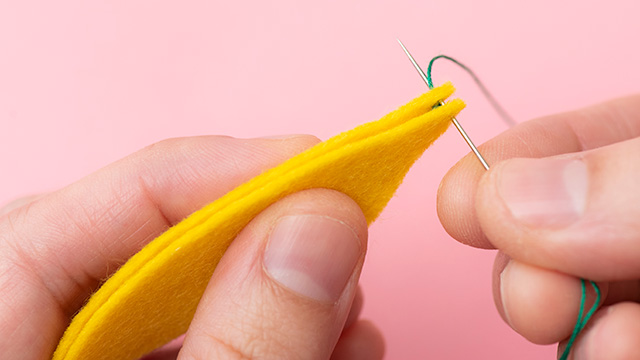 5．玉結びをはさむように手前に本体パーツをもう1枚を重ね、4と同じ位置に手前から奥へ針を出す。